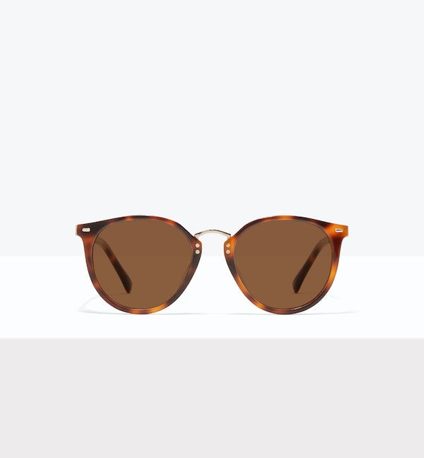 Tortoiseshell sunglasses with round brown lenses on a white background.